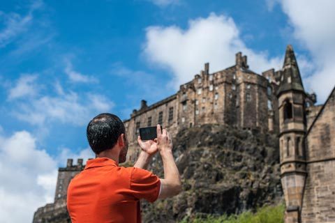 Man taking a picture of Edinburgh Castle